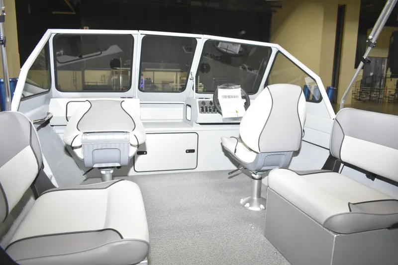 Slide: The Image of 2026 KingFisher 16 Falcon boat interior with seating and steering wheel, viewed from above. - 9