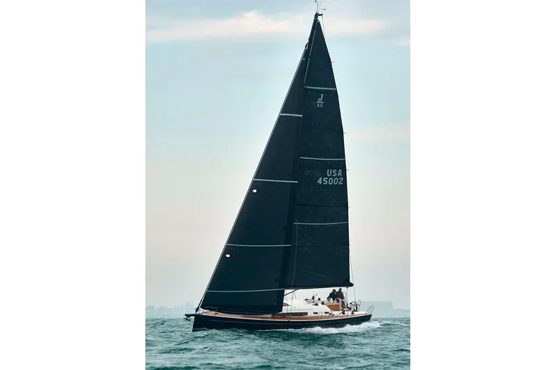 Slide: The Image of 2026 J Boats J/45 sailing on open water with sleek black sails. - 2