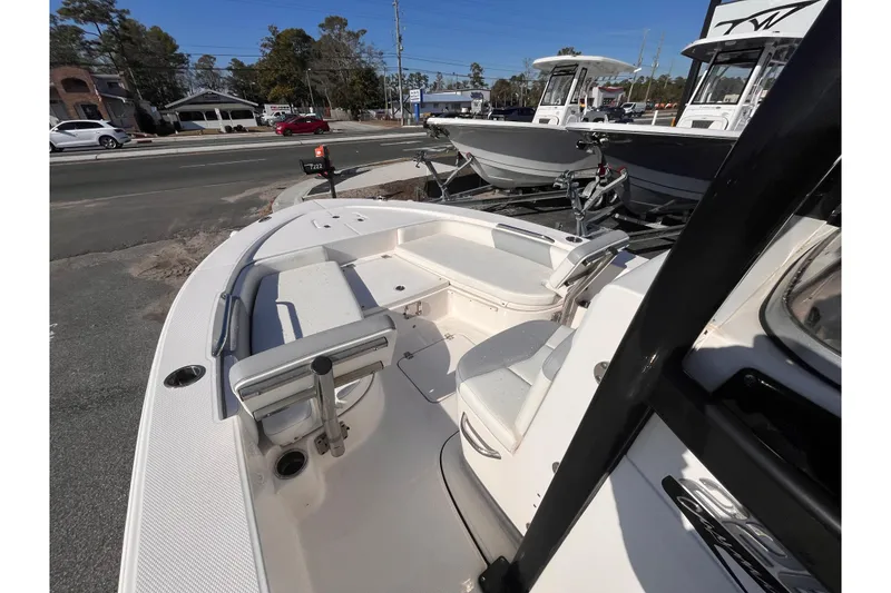 Slide: The Image of 2022 Robalo 226 Cayman boat interior with seating and storage, parked outdoors. - 14