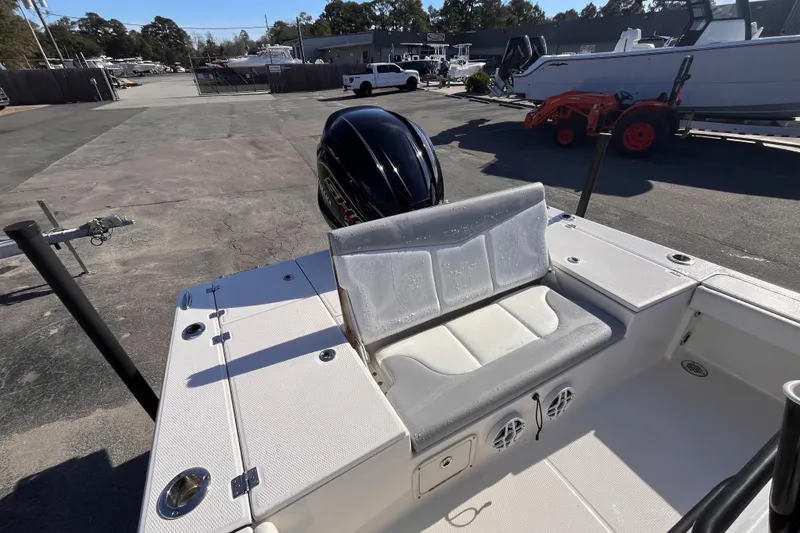 Slide: The Image of 2022 Robalo 226 Cayman boat interior with seating and outboard motor in a marina setting. - 6