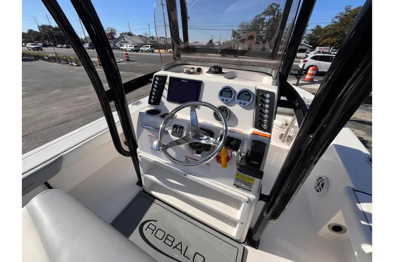 Slide: The Image of 2022 Robalo 226 Cayman boat dashboard with steering wheel and control panel. - 8