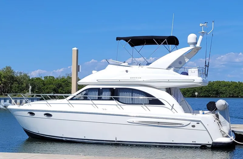 The Image of 2004 Meridian 341 Sedan yacht docked on a sunny day, featuring sleek white design. - 0
