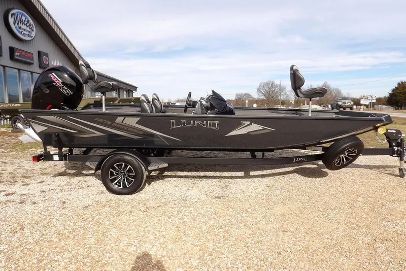 The Image of 2026 Lund 1975 Renegade boat on trailer, parked outside marine center. - 0