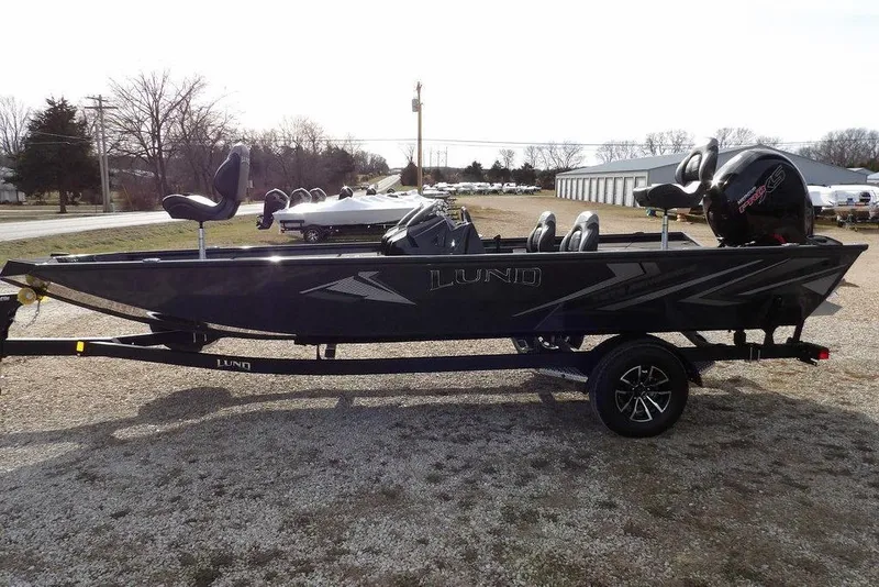 Slide: The Image of 2026 Lund 1975 Renegade boat on trailer, parked outdoors, side view. - 3
