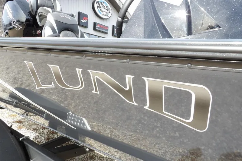 Slide: The Image of 2026 Lund 1975 Renegade boat with logo, parked at marine center. - 34