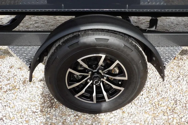 Slide: The Image of 2026 Lund 1975 Renegade trailer wheel with black alloy rim on gravel. - 39