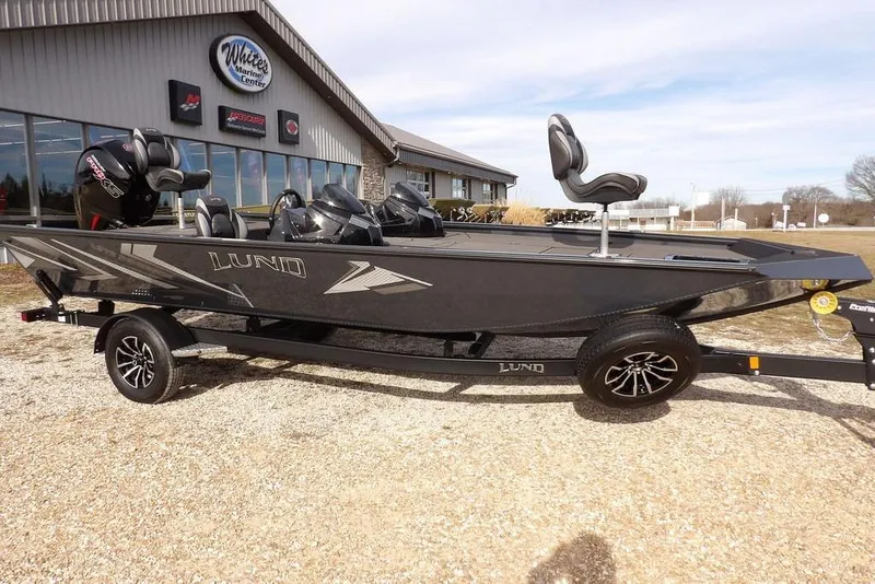 Slide: The Image of 2026 Lund 1975 Renegade boat on trailer outside marine center. - 41
