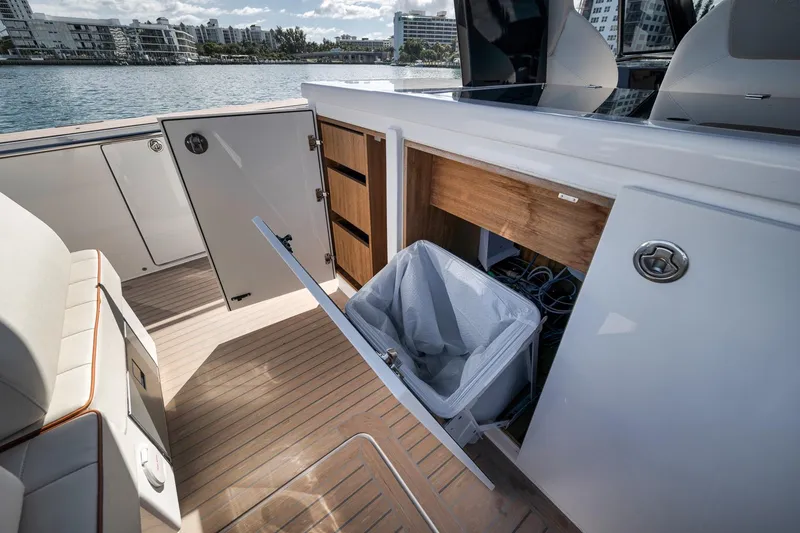 Slide: The Image of 2023 Pardo Yachts P43 interior with open storage compartments and trash bin on deck. - 13