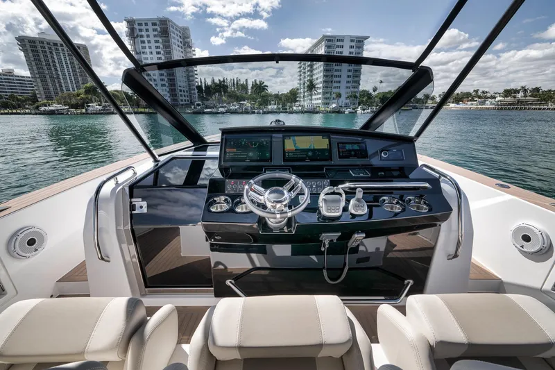 Slide: The Image of 2023 Pardo Yachts P43 helm with modern controls, overlooking waterfront cityscape. - 9