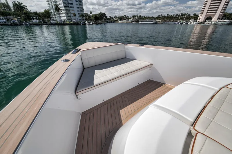 Slide: The Image of 2023 Pardo Yachts P43 deck with cushioned seating, overlooking calm waters and cityscape. - 10
