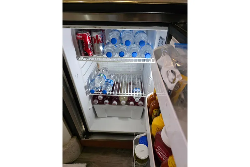 Slide: The Image of Mini fridge stocked with drinks and condiments on a 2000 Sea Ray 340 Sundancer boat. - 13