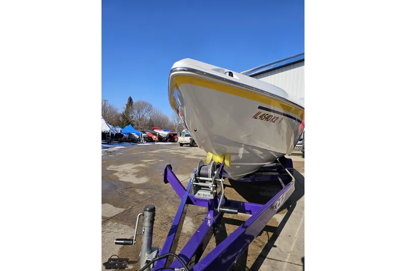 Slide: The Image of 2003 Baja 275 Boss boat on trailer, parked outdoors under clear blue sky. - 15
