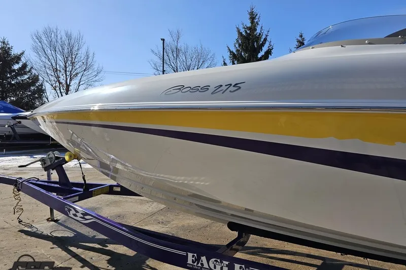Slide: The Image of 2003 Baja 275 Boss boat on trailer, featuring sleek design and vibrant yellow stripe. - 23