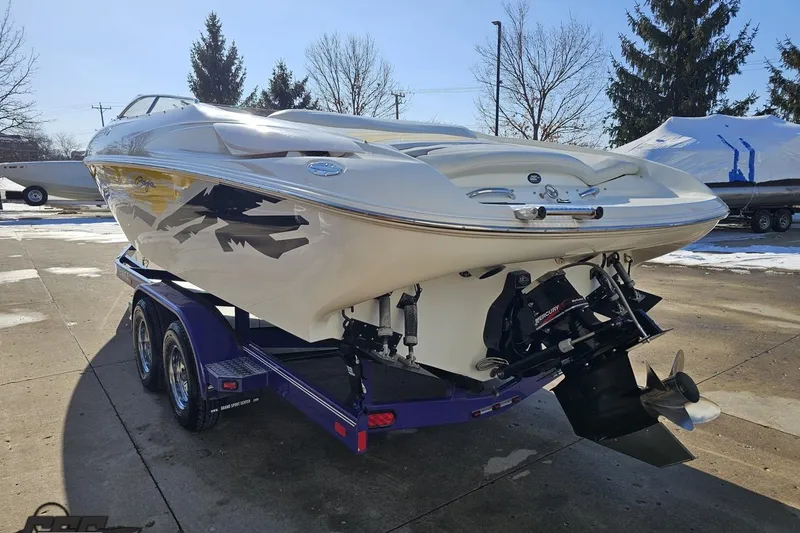 Slide: The Image of 2003 Baja 275 Boss boat on trailer, parked outdoors in a sunny setting. - 28