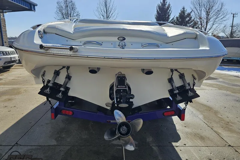Slide: The Image of 2003 Baja 275 Boss boat rear view with propeller and trim tabs in a sunny outdoor setting. - 30