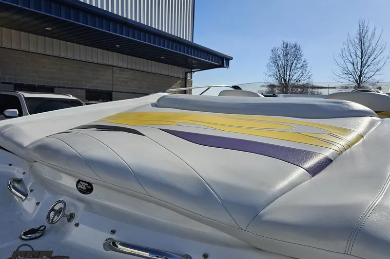 Slide: The Image of 2003 Baja 275 Boss boat with colorful upholstery design, parked outdoors. - 38