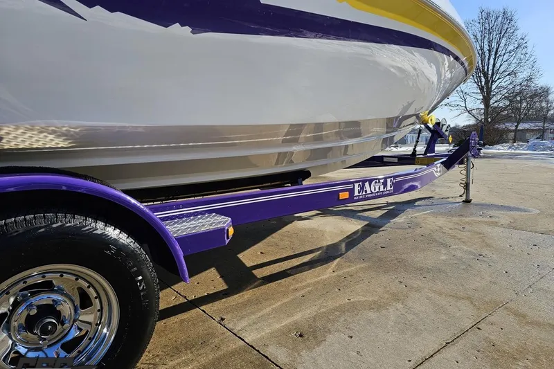 Slide: The Image of 2003 Baja 275 Boss boat on purple Eagle trailer, parked on concrete surface. - 39