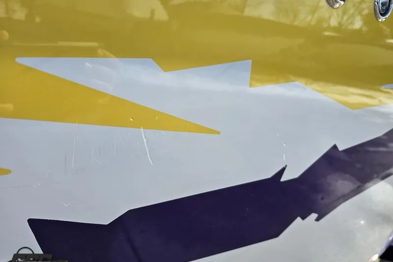 Slide: The Image of Close-up of 2003 Baja 275 Boss boat with vibrant yellow and purple graphics. - 40