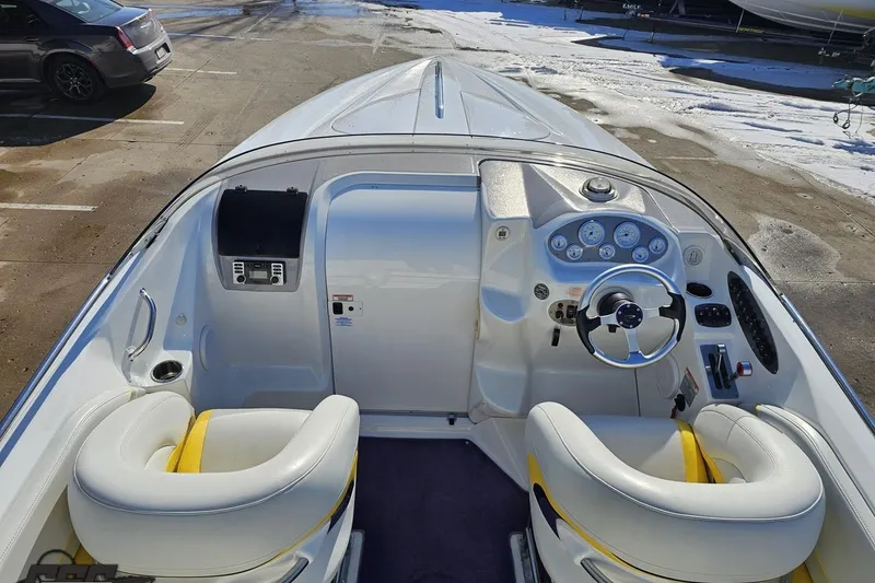 Slide: The Image of 2003 Baja 275 Boss boat interior with white and yellow seating, dashboard, and steering wheel. - 50