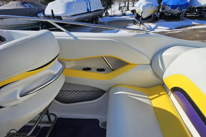 Slide: The Image of 2003 Baja 275 Boss boat interior with white and yellow seating, cup holders, and railing. - 54