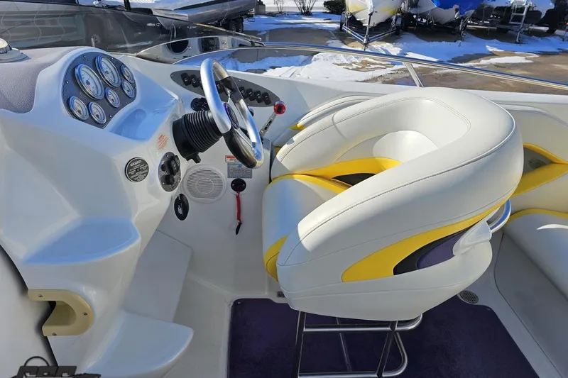 Slide: The Image of 2003 Baja 275 Boss boat cockpit with white and yellow seating, steering wheel, and gauges. - 65