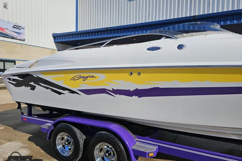 Slide: The Image of 2003 Baja 275 Boss boat with vibrant yellow and purple graphics on a trailer. - 7