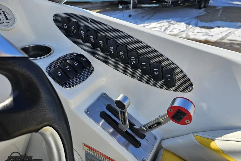 Slide: The Image of Control panel of a 2003 Baja 275 Boss boat with switches and throttle lever. - 70