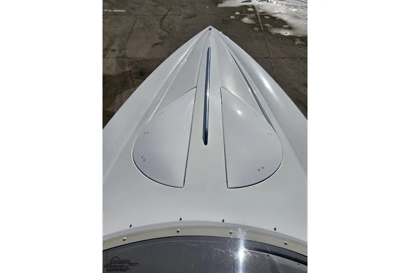 Slide: The Image of 2003 Baja 275 Boss boat bow, sleek white design on concrete surface. - 76