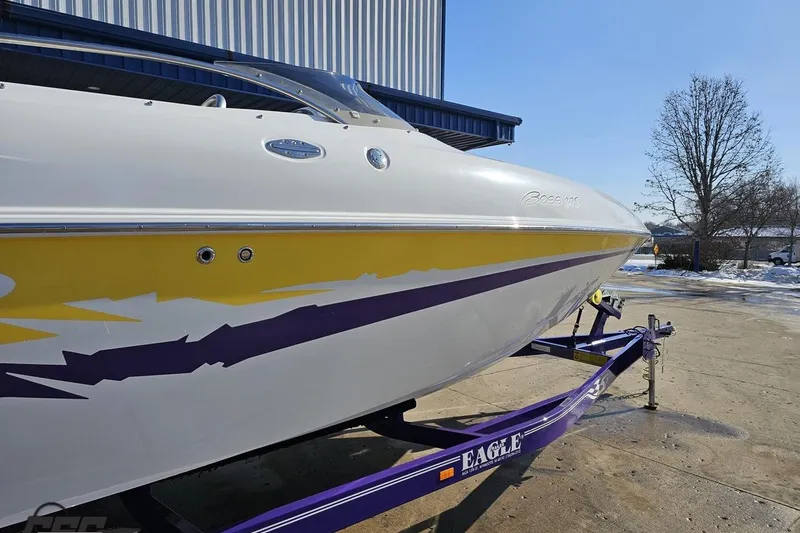 Slide: The Image of 2003 Baja 275 Boss boat with vibrant yellow and purple graphics on a trailer. - 9