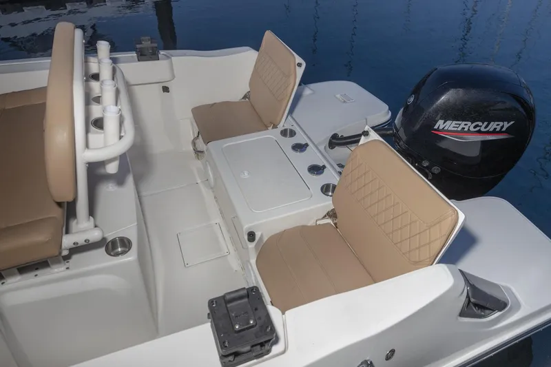 Slide: The Image of 2022 Bayliner Trophy T22CC boat interior with Mercury engine, featuring tan seating and storage compartments. - 11