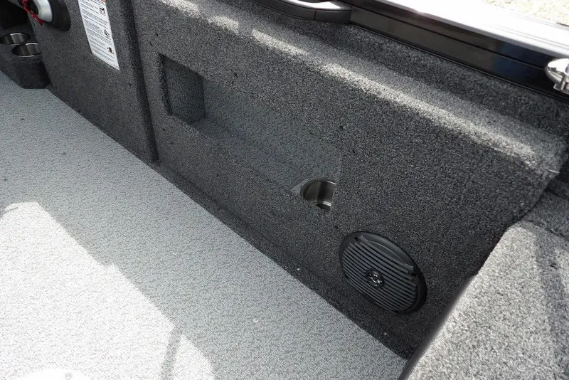 Slide: The Image of Interior of 2025 Crestliner 1850 Fish Hawk Tiller boat, featuring carpeted storage and speaker. - 13