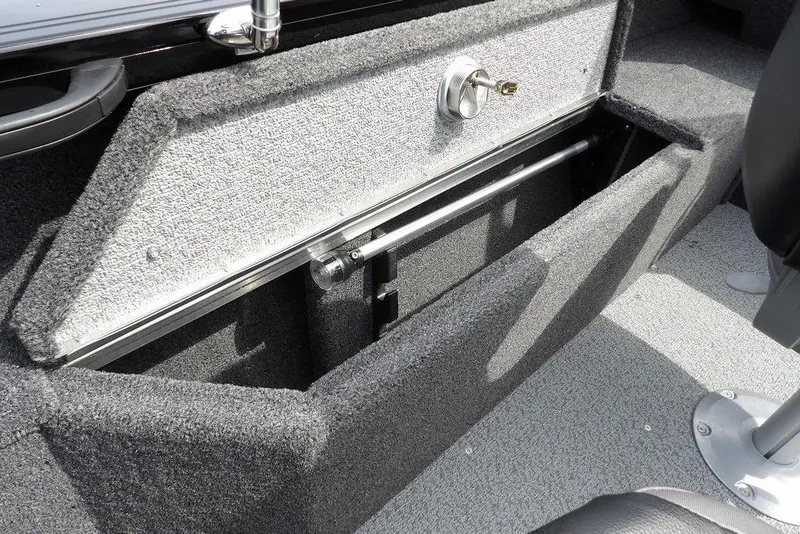 Slide: The Image of 2025 Crestliner 1850 Fish Hawk Tiller storage compartment with secure lock and carpeted interior. - 14