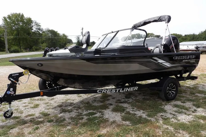 Slide: The Image of 2025 Crestliner 1850 Fish Hawk Tiller boat on trailer, parked outdoors. - 3