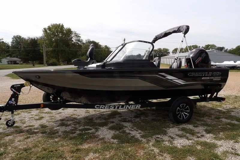 Slide: The Image of 2025 Crestliner 1850 Fish Hawk Tiller boat on trailer, parked outdoors. - 5