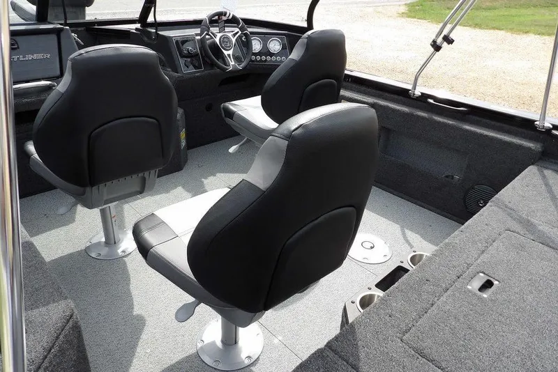 Slide: The Image of 2025 Crestliner 1850 Fish Hawk Tiller interior with two black seats and steering console. - 9