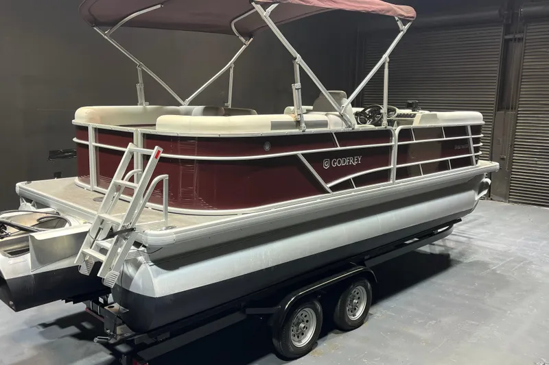Slide: The Image of 2023 Godfrey Sweetwater 2286 C pontoon boat with maroon and white design on a trailer. - 5
