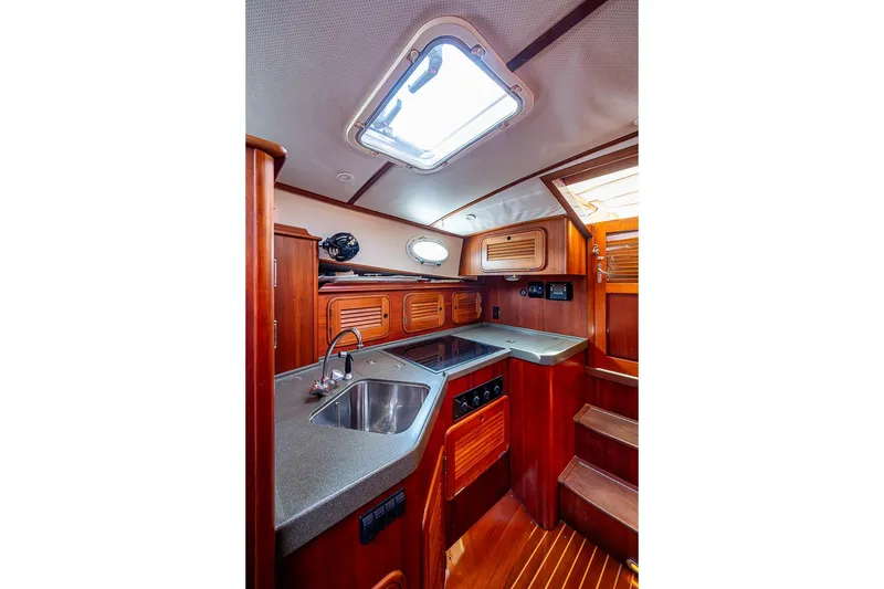 Slide: The Image of 2002 Hinckley Talaria 40 yacht interior kitchen with wood cabinetry and modern appliances. - 9