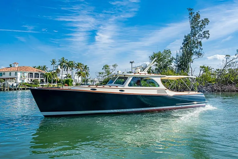 The Image of 2002 Hinckley Talaria 40 yacht cruising on a sunny day near waterfront homes. - 0