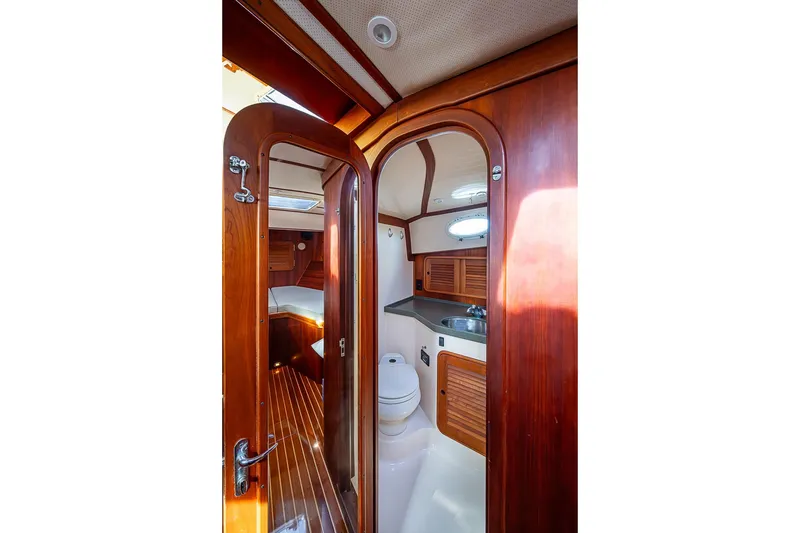 Slide: The Image of Interior of 2002 Hinckley Talaria 40 yacht, featuring wooden cabinetry and compact bathroom. - 12