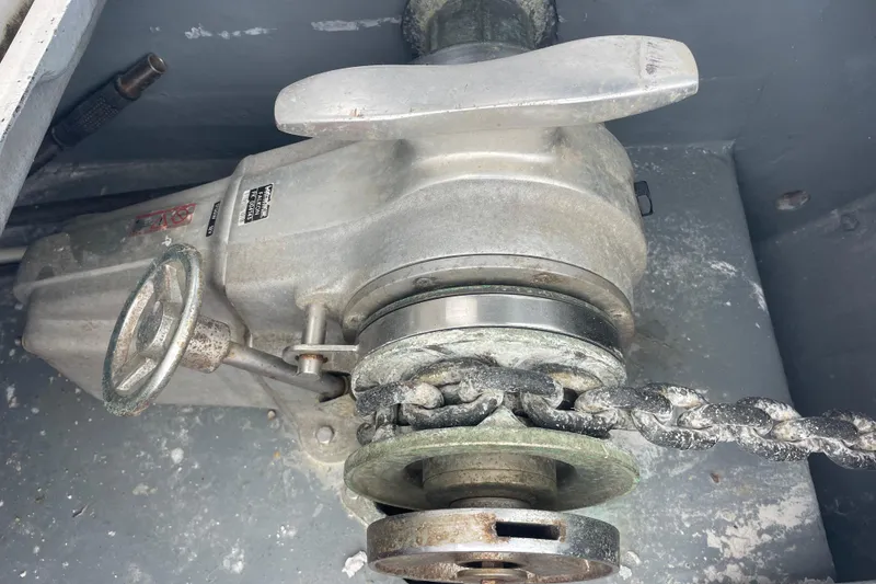 Slide: The Image of Windlass mechanism on a 2004 Lagoon 570 yacht, featuring a chain and manual handle. - 12