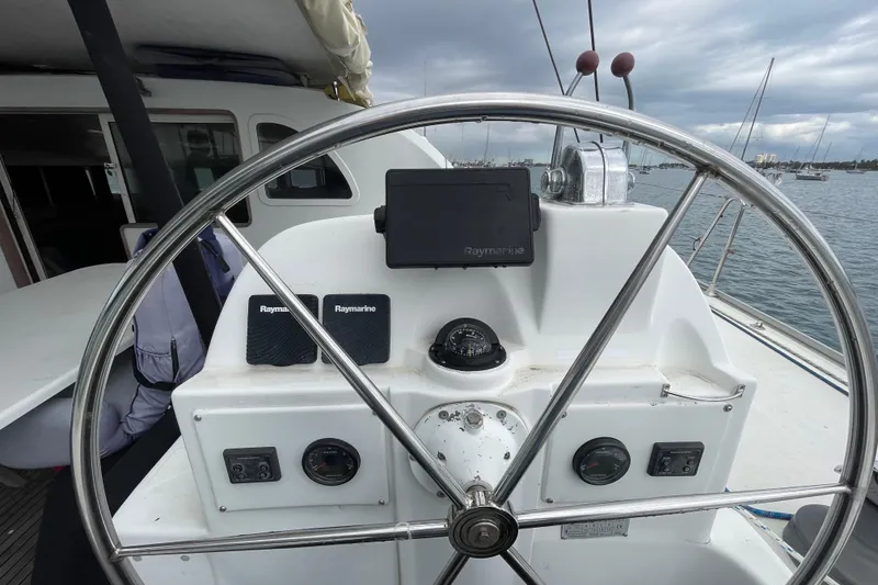 Slide: The Image of Steering wheel of 2004 Lagoon 570 yacht with navigation equipment, docked in a marina. - 15
