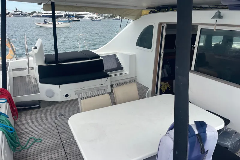 Slide: The Image of 2004 Lagoon 570 yacht deck with seating, table, and ocean view. - 17