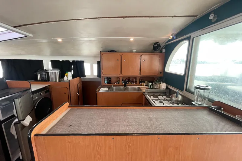 Slide: The Image of Interior of 2004 Lagoon 570 yacht kitchen with wooden cabinets and modern appliances. - 26