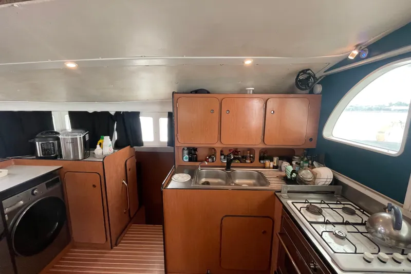 Slide: The Image of Interior of 2004 Lagoon 570 yacht kitchen with wooden cabinets and modern appliances. - 27