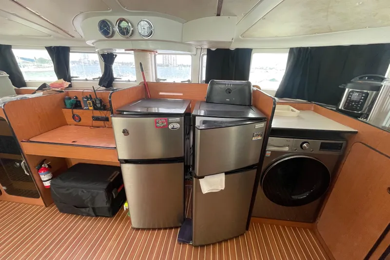 Slide: The Image of Interior of 2004 Lagoon 570 yacht with kitchen appliances and wooden cabinetry. - 30