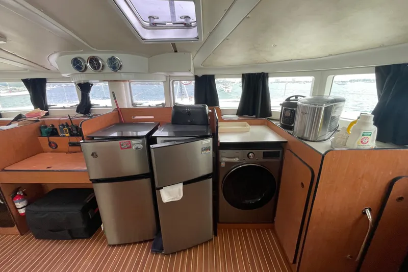 Slide: The Image of Interior of 2004 Lagoon 570 yacht with kitchen appliances and wooden cabinetry. - 32