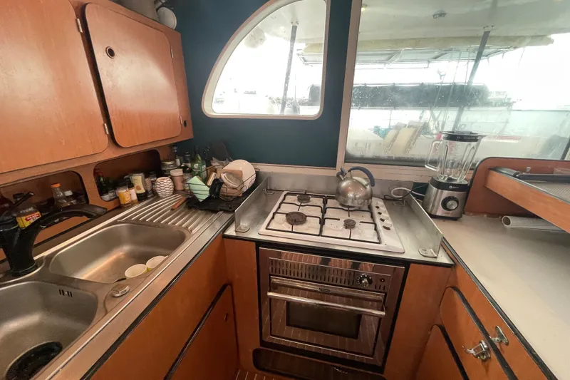 Slide: The Image of 2004 Lagoon 570 yacht kitchen with stove, sink, and blender. - 34