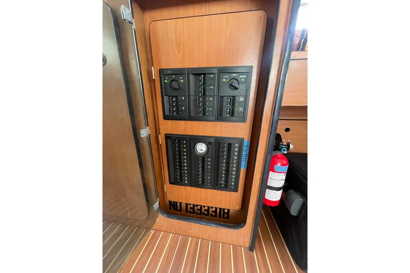 Slide: The Image of Electrical panel on 2004 Lagoon 570 yacht with fire extinguisher nearby. - 36