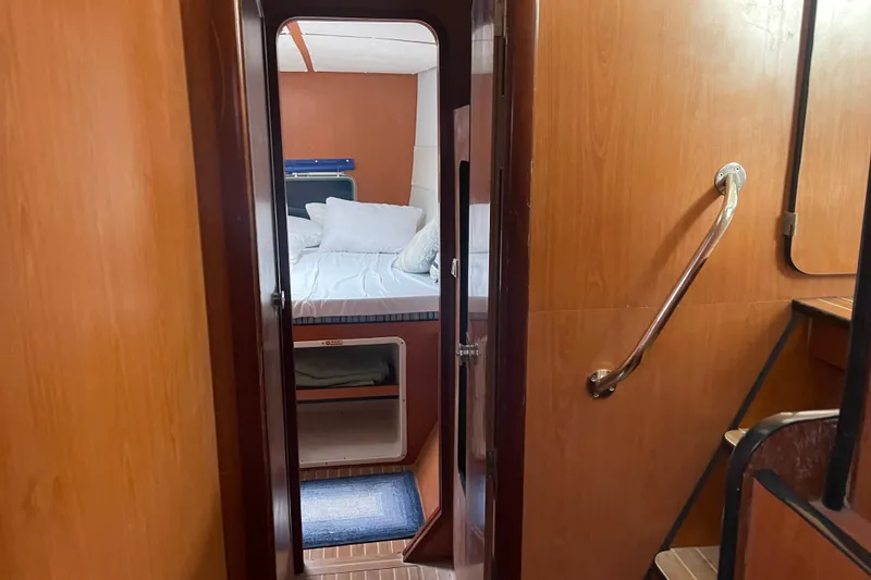 Slide: The Image of Interior cabin view of 2004 Lagoon 570 yacht, featuring cozy bed and wooden paneling. - 39