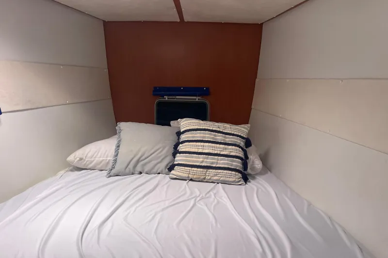 Slide: The Image of Cozy cabin bed in 2004 Lagoon 570 yacht with pillows and white bedding. - 40